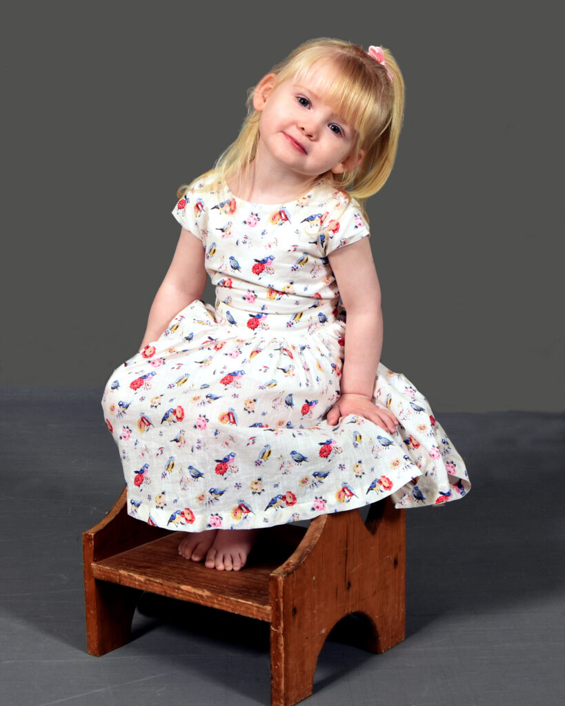A Lovely Young Girl Sitting on a Stool